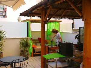a young girl standing in a room with a green curtain at Hotel Maravillas del Mundo in Calpe