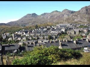 a small town with houses and mountains in the background at Snowdonia miners cottage in Blaenau-Ffestiniog