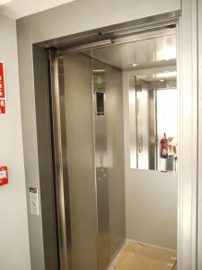 a sliding glass door in a elevator in a room at Hotel Maravillas del Mundo in Calpe