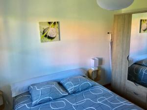 a bedroom with a blue bed with pillows on it at Le Grasberg in Bergheim