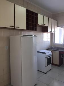 uma cozinha com armários brancos e um frigorífico em Apto em ótima localização! em Lages