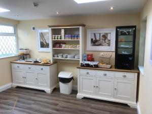 a kitchen with white cabinets and a dog in it at Almorah Hotel in Saint Helier Jersey