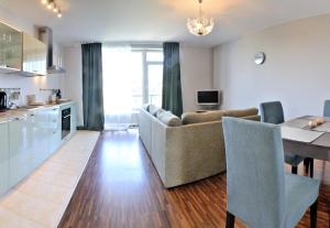 a living room and kitchen with a couch and a table at Kaminkelio apartment 44 in Vilnius