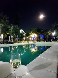 um copo de vinho sentado ao lado de uma piscina à noite em Vila Sejuda em Peschici