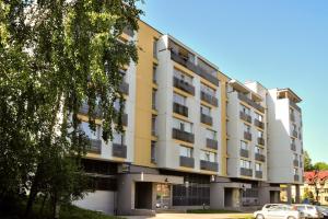 un edificio de apartamentos de color amarillo y blanco en Kaminkelio apartment 44 en Vilna