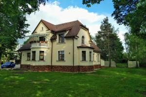 una casa blanca con techo marrón en Villa Garden Apartments, en Poprad