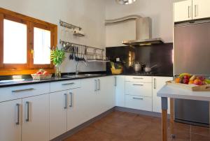 a kitchen with white cabinets and a bowl of fruit at La Casa de Enmedio in San Vicente del Valle