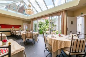 a dining room with tables and chairs and windows at The Black Swan Hotel in Bruges