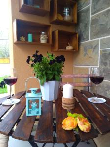 una mesa de madera con dos copas de vino y una planta en Beach house with garden, en Sintra