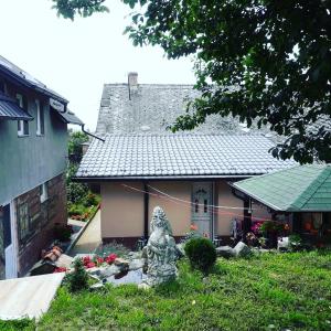 a small house with a statue in front of it at Apartman Darija in Vrdnik