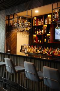 un bar con sedie e un bancone con bottiglie di liquore di Hotel Riazor Aeropuerto a Città del Messico