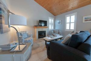 a living room with a couch and a fireplace at Lantern Hill & Hollow in Ingonish Beach