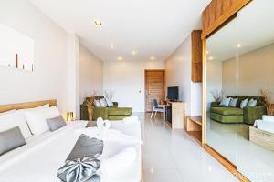 a bedroom with a large bed and a living room at Lemonade Phuket Hotel -SHA Plus in Chalong