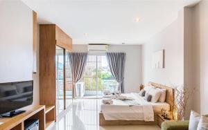 a living room with a bed and a television at Lemonade Phuket Hotel -SHA Plus in Chalong