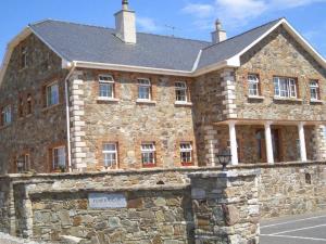 a large stone building with a stone wall at Tomedjocon in Fermoy