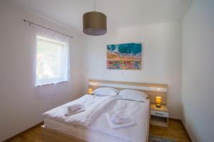 a bedroom with a bed with two towels on it at Villa Nikola - pool side apartments in Bol +49 photos