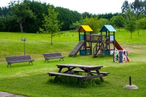 un parque con parque infantil con bancos y mesa de picnic en Apartamentos Rurales Larrago, en Busturia