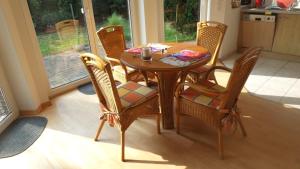 a dining room table with wicker chairs in a kitchen at Ferienwohnung Ahausen in Ahausen