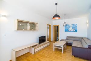 a living room with a couch and a tv at Villa Nikola - pool side apartments in Bol