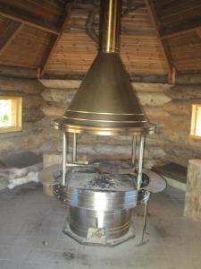 een grote metalen kachel in een kamer met een plafond bij Rukakaiku Cottages in Ruka