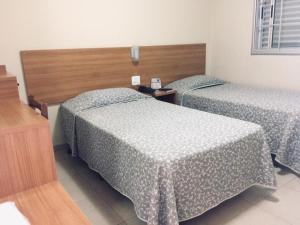 two beds in a hotel room with at Primavera Palace Hotel in Nova Andradina +7 photos