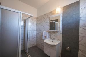 a bathroom with a white sink and a shower at Deniz Airport Suites in Lefkosa Turk