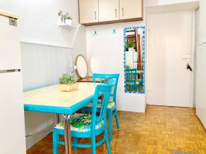 a kitchen with a blue table and chairs at Simply Best HOLIDAY , Cash Pay & Free is - Parking, Aircool, Tv, 2 Person in Lovran