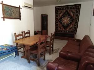 sala de estar con mesa de madera y sillas en colors house, en Alghero