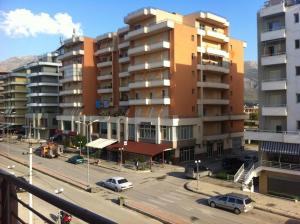 a large building with cars parked in a parking lot at Big apartment in Orikum