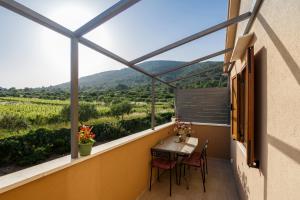 a balcony with a table and chairs and a view at Apartments Mardešić in Komiža