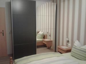 een kamer met een slaapkamer met een bed en een spiegel bij Mosel-Ferienwohnung Berhard in Bruttig-Fankel