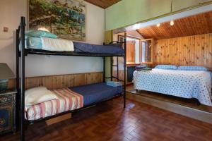 Sant ArcangeloにあるChalet sul Trasimenoの二段ベッド2台とベッド1台が備わる客室です。