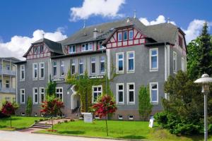 齊諾維茨的住宿－Vineta Strandhotels，一座大型灰色建筑,有红色屋顶