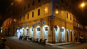 a group of motorcycles parked outside of a building at night at Hotel Istria in Trieste