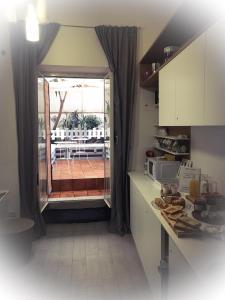una cucina con porta che conduce a un patio con balcone di B&B La Giara a Porto Empedocle