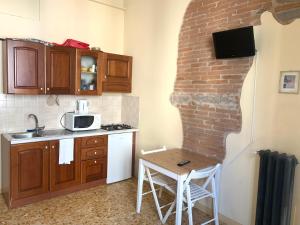 フィレンツェにあるFlorentia Homeのレンガの壁、テーブル付きのキッチン