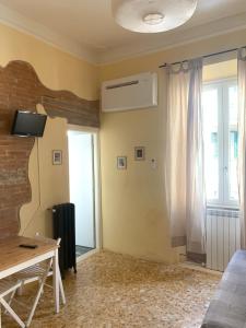 フィレンツェにあるFlorentia Homeのベッド、デスク、窓が備わる客室です。