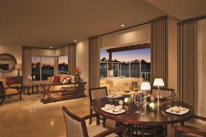 a dining room with a table and chairs and a living room at Dreams Dominicus La Romana Resort & Spa in Bayahibe +37 photos