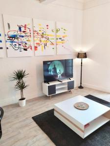 un soggiorno con TV e tavolo di Confort Appart a Béziers