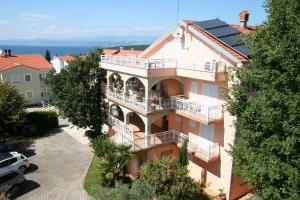 a large building with a balcony and the ocean at Apartments and Rooms Njivice in Njivice
