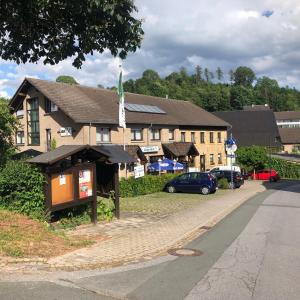 een groot gebouw met auto's geparkeerd voor het bij Landgasthaus Jägerhof in Büren