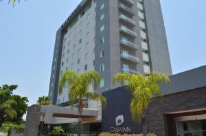 a tall building with palm trees in front of it at Casa Inn Business Hotel Celaya in Celaya