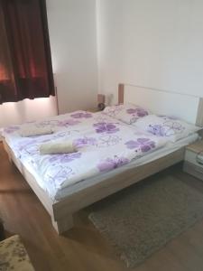uma cama com flores roxas num quarto em Apartments Ivanka em Ston
