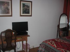 a bedroom with a desk with a television and a bed at Magnolia B&B in Granby