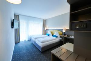 Un pat sau paturi într-o cameră la Hotel Holiday Thun
