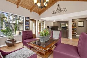 uma sala de estar com cadeiras roxas e uma mesa em Ramada by Wyndham Mountain View em Mountain View