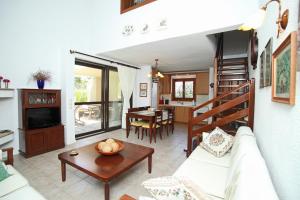 a living room with a couch and a table at Villa Sanni Retreat by Luxlikehome in Sani Beach