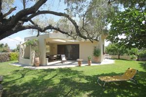 a yard with a chair and a house at Villa Sanni Retreat by Luxlikehome in Sani Beach