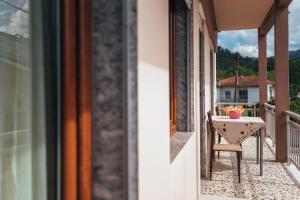 a table and chair on the balcony of a house at Roxanne’s Home in Limenas