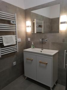 La salle de bains est pourvue d'un lavabo blanc et d'un miroir. dans l'établissement Sielankowy Domek, à Ośno Lubuskie
